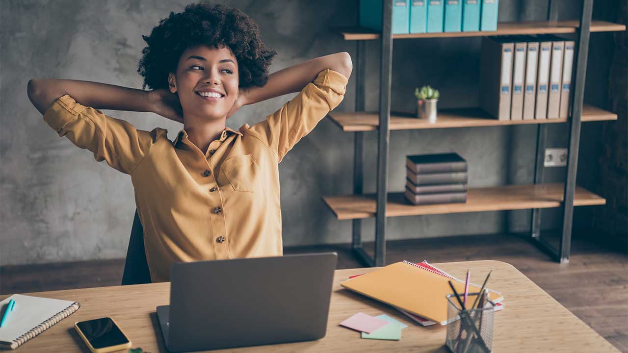 Woman leaning back from desk smiling